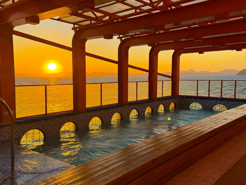 夕日に染まる海と船上のインフィニティプール