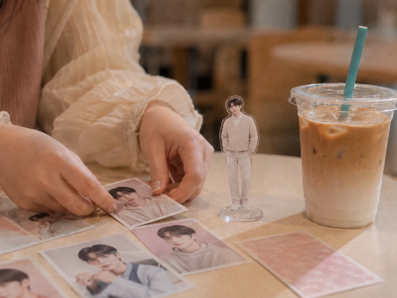 ソウルのカフェでK-POPグッズを並べて推し活を楽しむ女性のイメージ